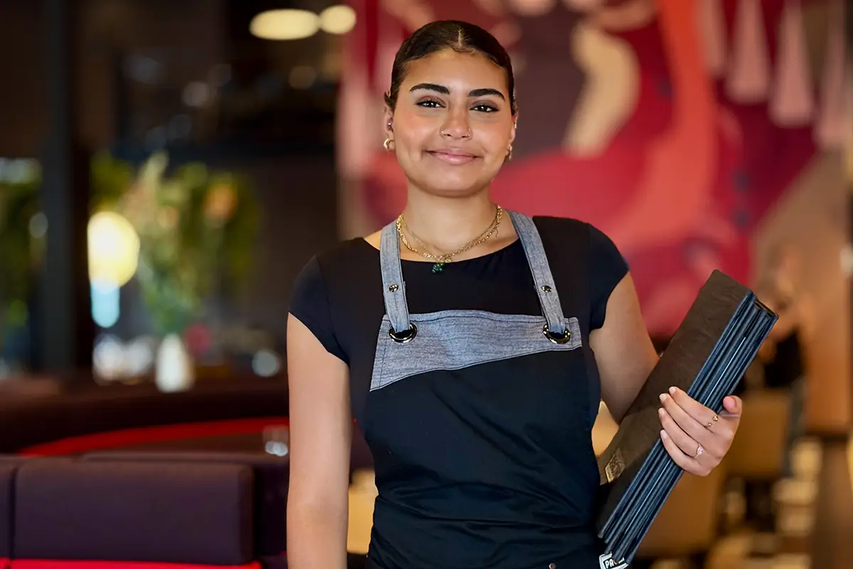 PACINI employee serving a customer in the dining room.