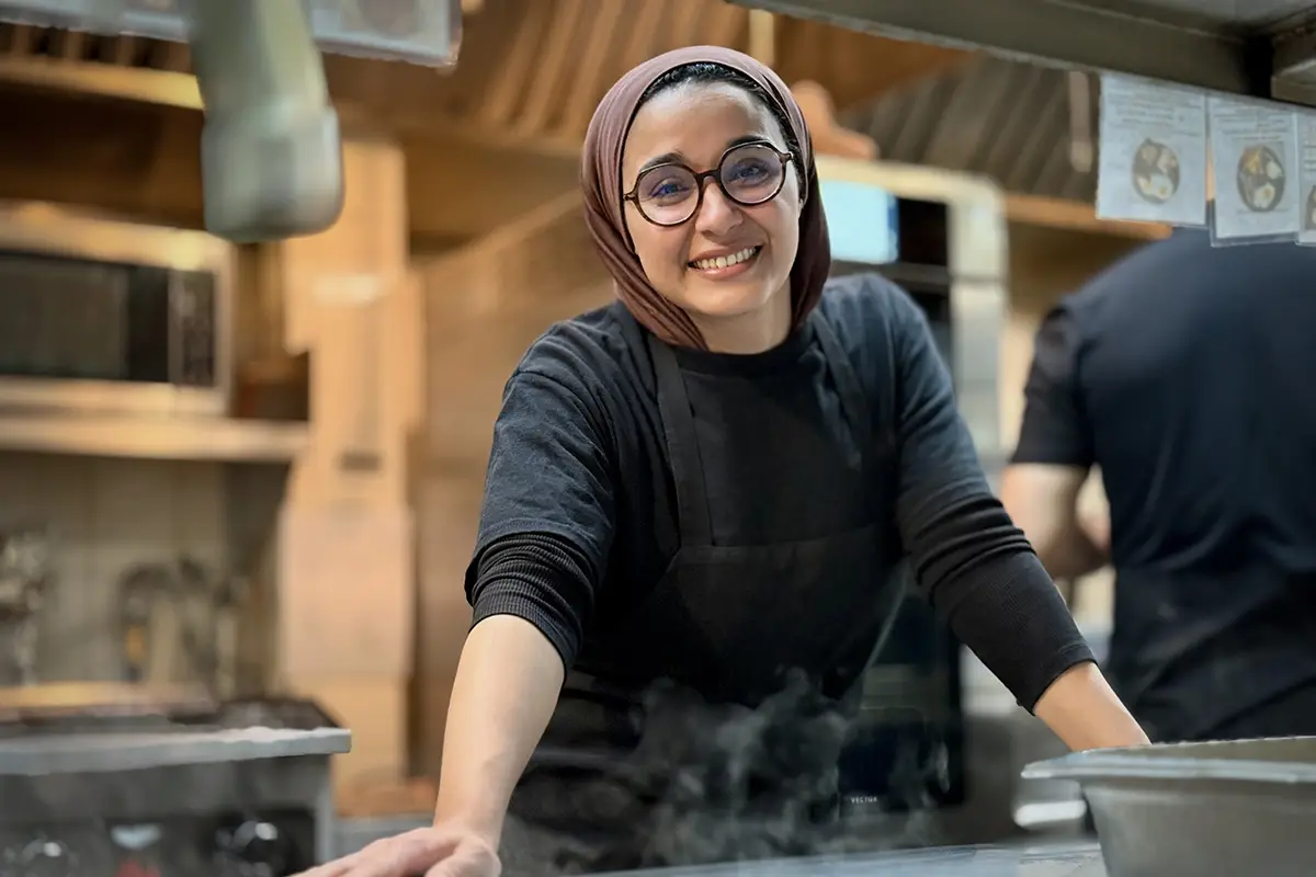 PACINI employee preparing a dish in the kitchen.